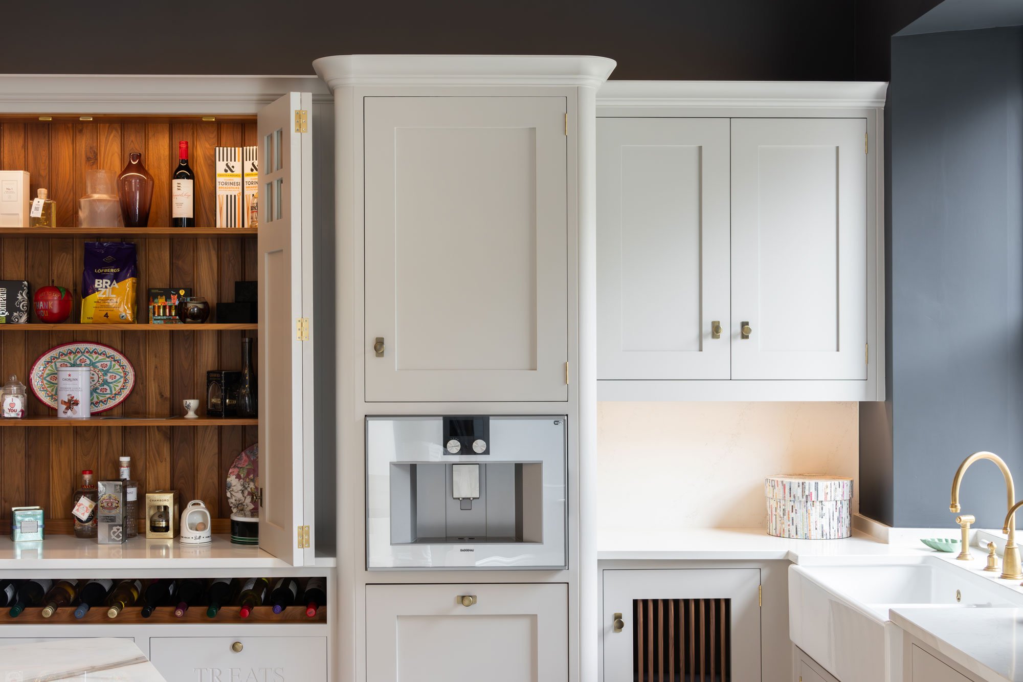 A modern, grey and white kitchen featuring Crofts & Assinder handles